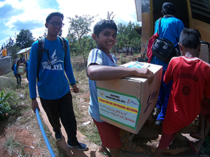 ANGKAT: Seorang murid SD Inpres Camplong 2 mengangkat bantuan berupa buku ke perpustakaan